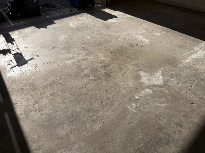 Detail photo of a cracked and dirty garage floor in Irving, Texas.