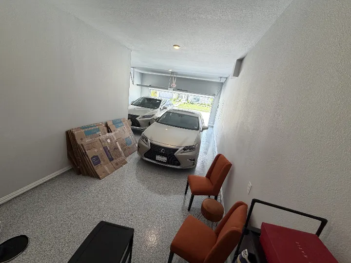 Garage with epoxy floor coating in Prosper, Texas, with cars and furniture.