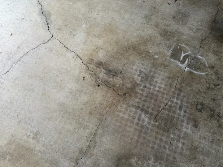 Before photo of cracked and worn garage floor in Euless, Texas.