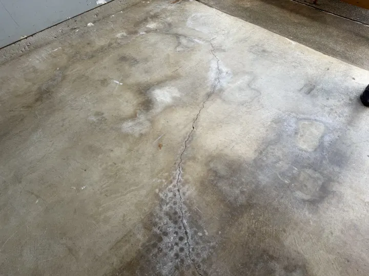 Before photo of a worn garage floor in Euless, Texas.